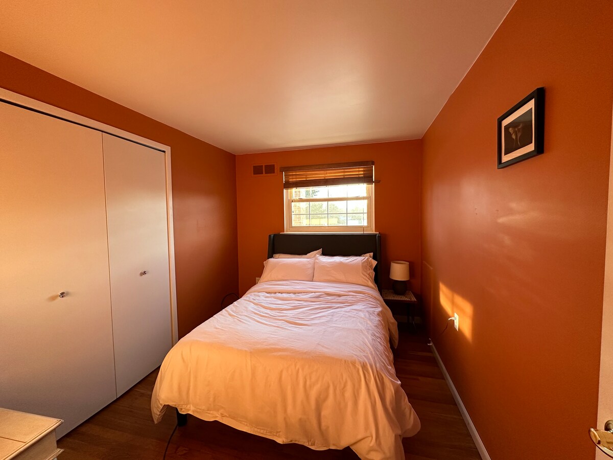 غرفة نوم بسرير بالحجم الكامل ومساحة خزانة تقع في الطابق العلوي