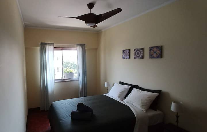 Спална соба со брачен кревет и тивок вентилатор.