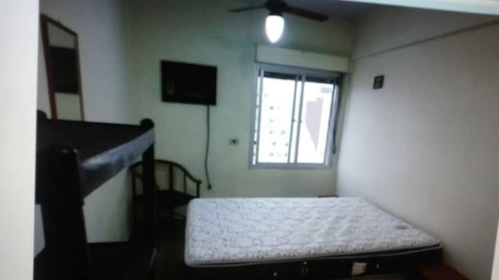 غرفة نوم بها مروحة سقف وتلفزيون.