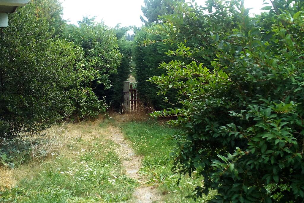 Une partie du jardin avec sa petite porte dérobée permettant de partir directement à pied au village ou bien en randonnée.