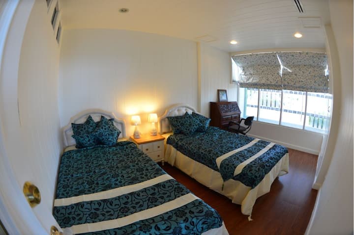 חדר שינה תחתון, 2 מיטות יחיד עם מיטת יחיד רזרבית מתחתיה.