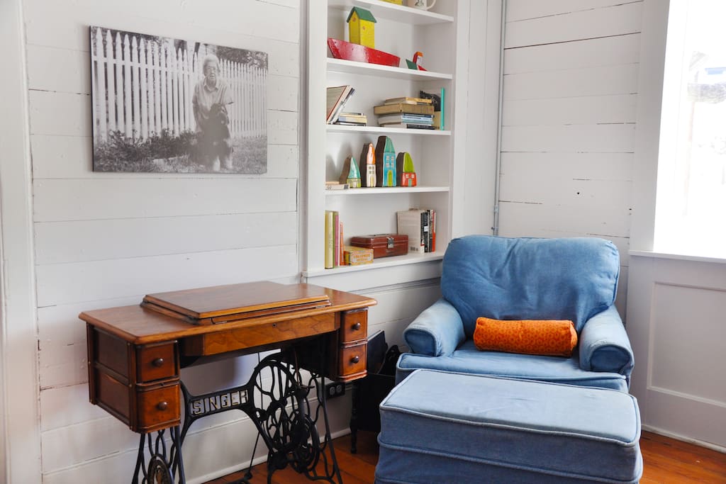 One of Mimi's treadle sewing machines is tucked under a photo of Mimi near the white picket fence.