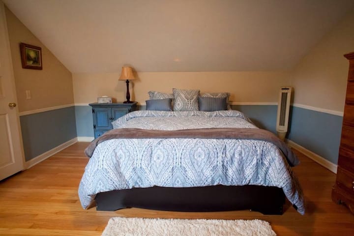 Upstairs bedroom with queen memory foam bed and a wooden crib. We also have a pack and play available.