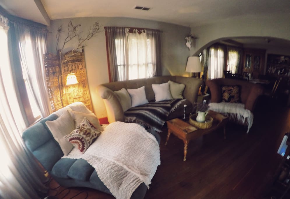 Entrance to the house, living room couches throw pillows and blankets.