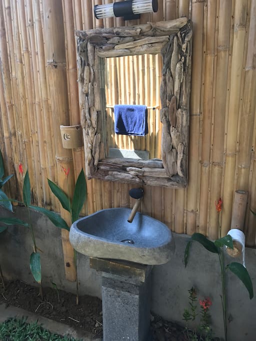 Stone and bamboo tap, stone sink with a volcanic stone pedestal