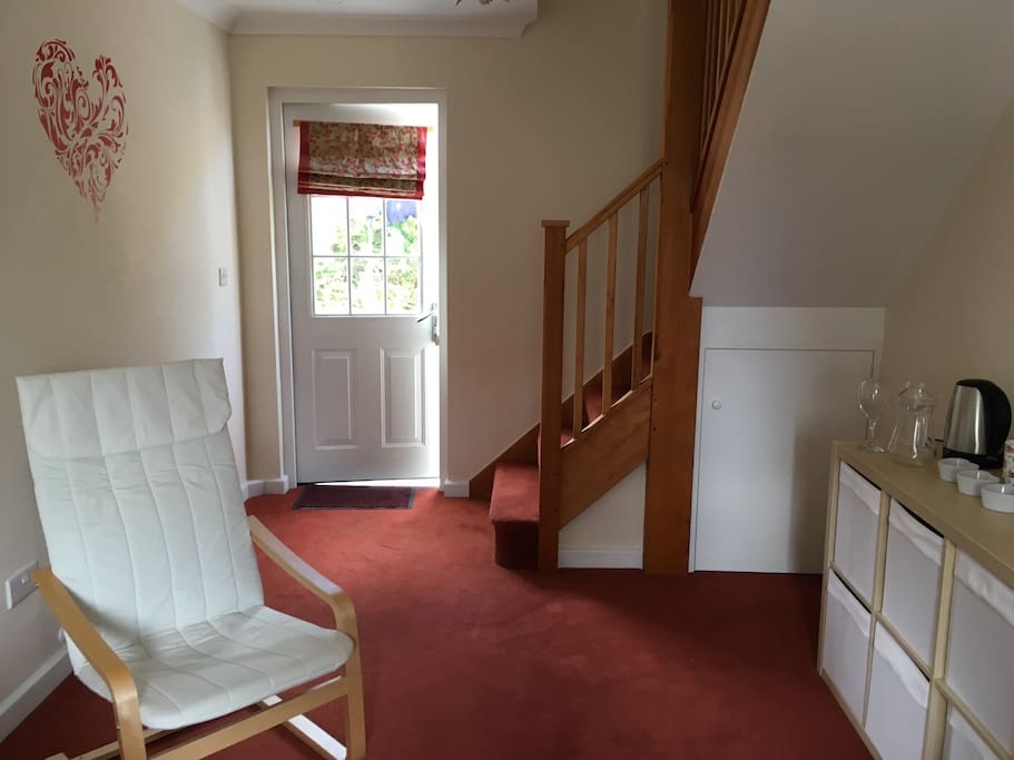 Private living room, showing the entrance door and stairs up to bedroom. Space available for double air bed/child's bed and/or cot (please ask on booking and these can be set-up for arrival). Children's books, games and toys can be found in shelf storage. Extra bedding and towels can be found in under stairs storage cupboard. Kettle, toaster, fridge and tea/coffee facility.