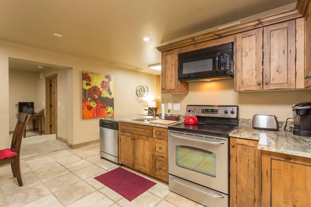Full sized kitchen with Kuerig machine, stainless steel appliances and granite countertops.