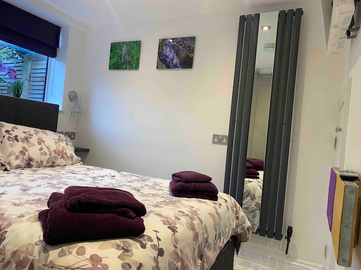 Beneden slaapkamer met tweepersoonsbed is voorzien van een chique spiegelradiator over de volledige lengte voor haarstyling en het controleren van de outfit, een smart-tv, een kleine ingebouwde kledingkast, een kluisje aan de muur en een haardroger.
* Helaas niet geschikt voor rolstoelgebruikers.
