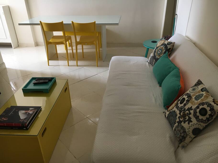 Sala com sofá-cama para casal e mesa para até 6 lugares