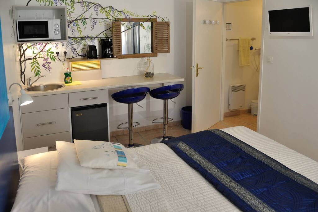 Kitchenette avec évier, frigo, micro onde grill, coin repas, bouilloire et cafetière. Salle de bain avec douche, lavabo et WC.