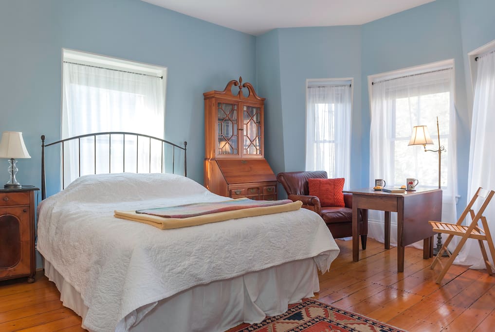 Queen-sized bed in bright and airy room.