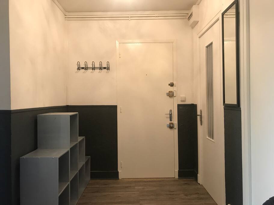 La porte de l’appartement s’ouvre sur une entrée avec porte-manteaux et range-chaussures. À gauche se trouvent les deux grandes chambres et à droite les sanitaires et la salle d’eau. Le salon et la cuisine se situent dans la continuité de l’entrée.