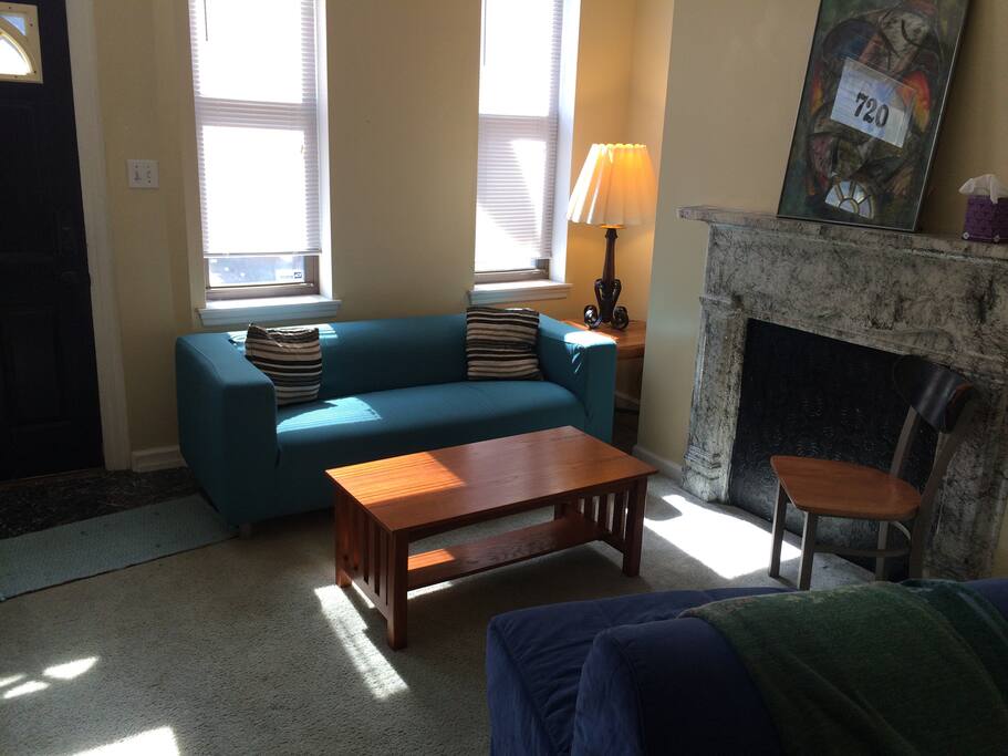 Shared living room on first floor of house. Front door is on the left.