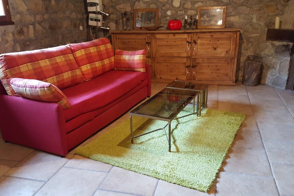 Pièce à vivre de 60 M2 avec un coin salon avec une cheminée.
