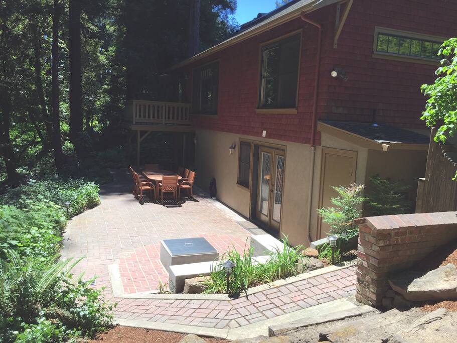 Pathway to downstairs apartment with two sets of french doors, outdoor fire pit and table