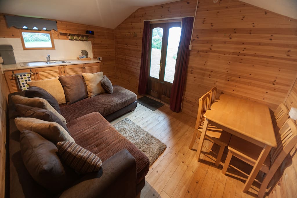 Large lounge with L-shaped sofa/chaise and small kitchenette area