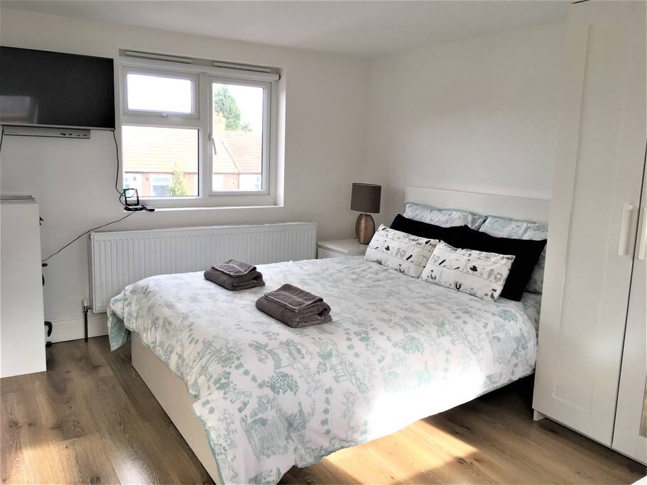 Double bed with TV and side window over looking garden - viewing by the small dinning table.
