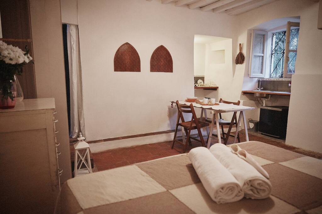 La camera con vista sul l'angolo cottura e la tavola da pranzo ricavata da una vecchia porta /The room with the kitchen corner and dining table, originally an ancient little door