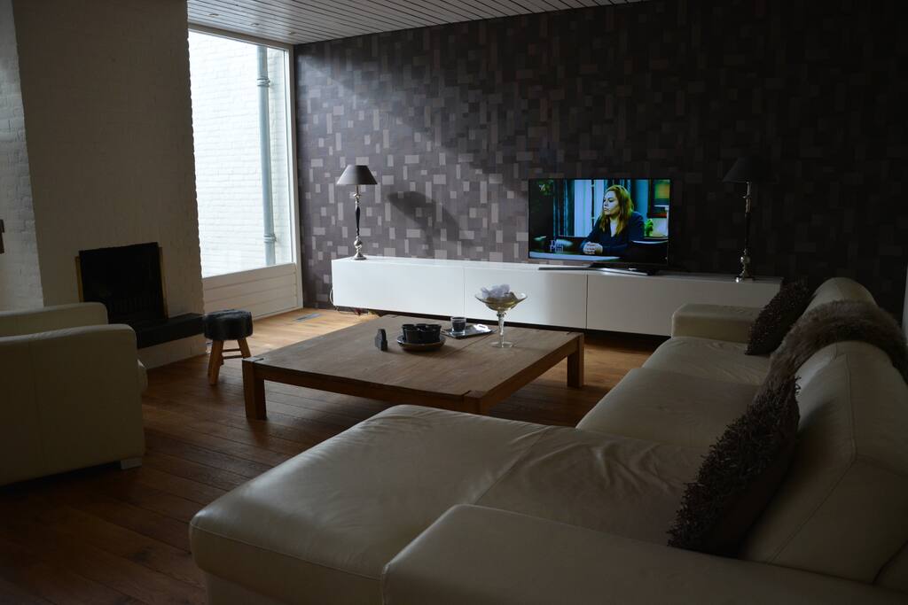 watching a wide screen smart tv on a big lounge couch.