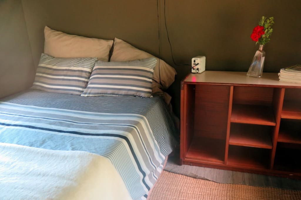 Double bed and bedside table inside the tent.