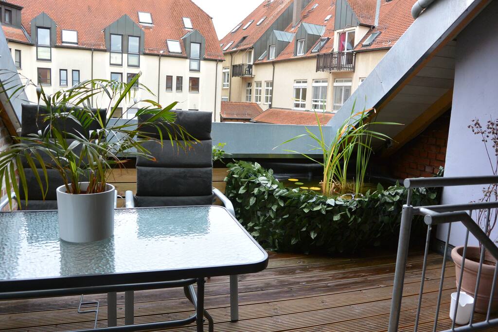 Dachterrasse mit Polster Stühlen und Liege .