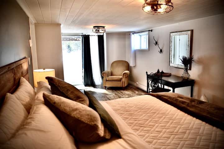 Main bedroom with direct access to the backyard and hot tub. Includes a desk and a cozy sitting area — perfect for relaxing or getting a bit of work done.