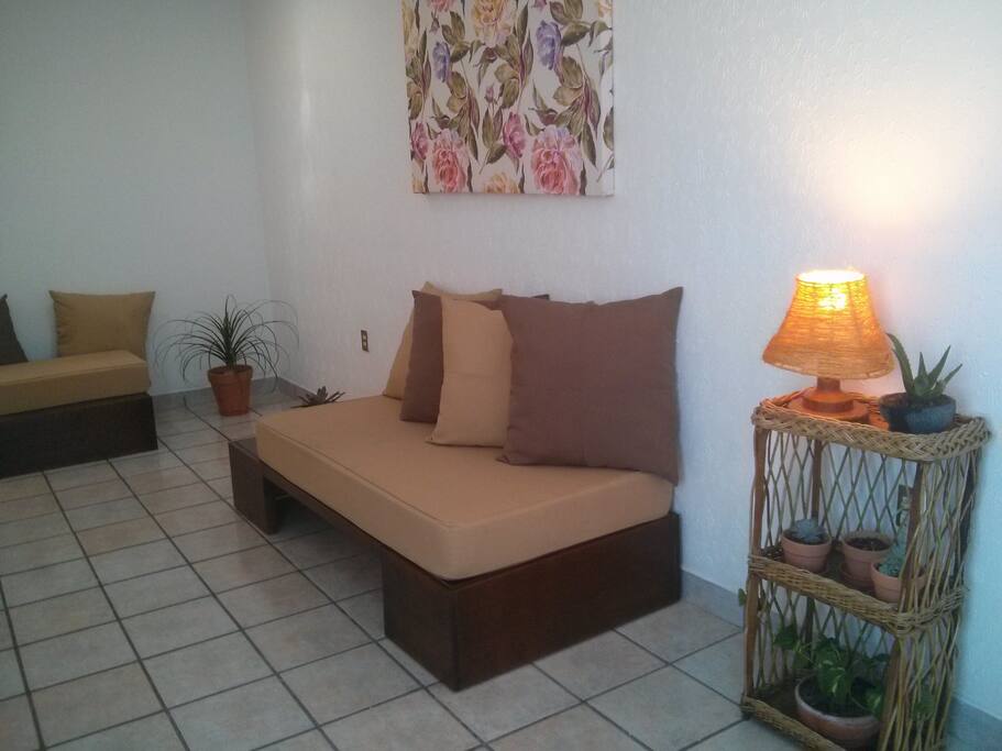 Sala con sofá para tres personas y sillón.