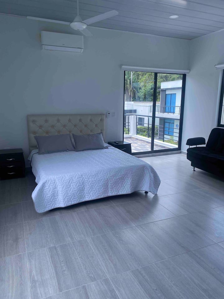 Alcoba principal con cama Queen y sofá cama para dos personas, amplio patio con sala y excelente vista