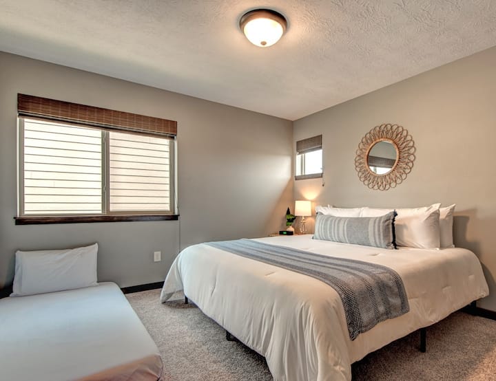 The king bedroom upstairs includes a twin floor mattress for extra sleeping space. There's also a closet with shelving and a smart TV.