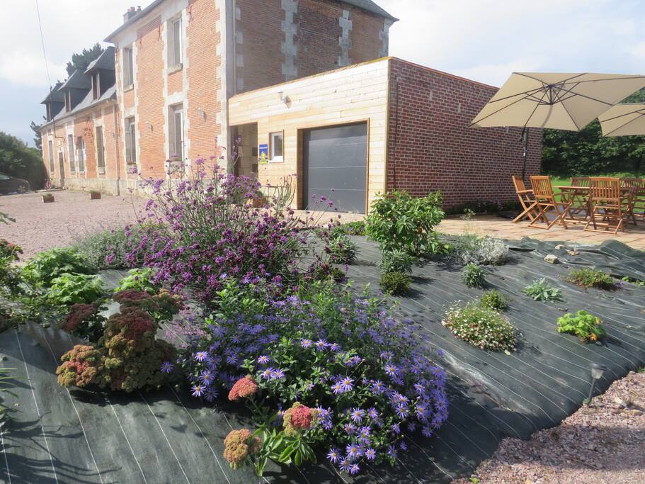 L'extérieur de la maison avec son espace abrité fumeur, sa terrasse et le jardin