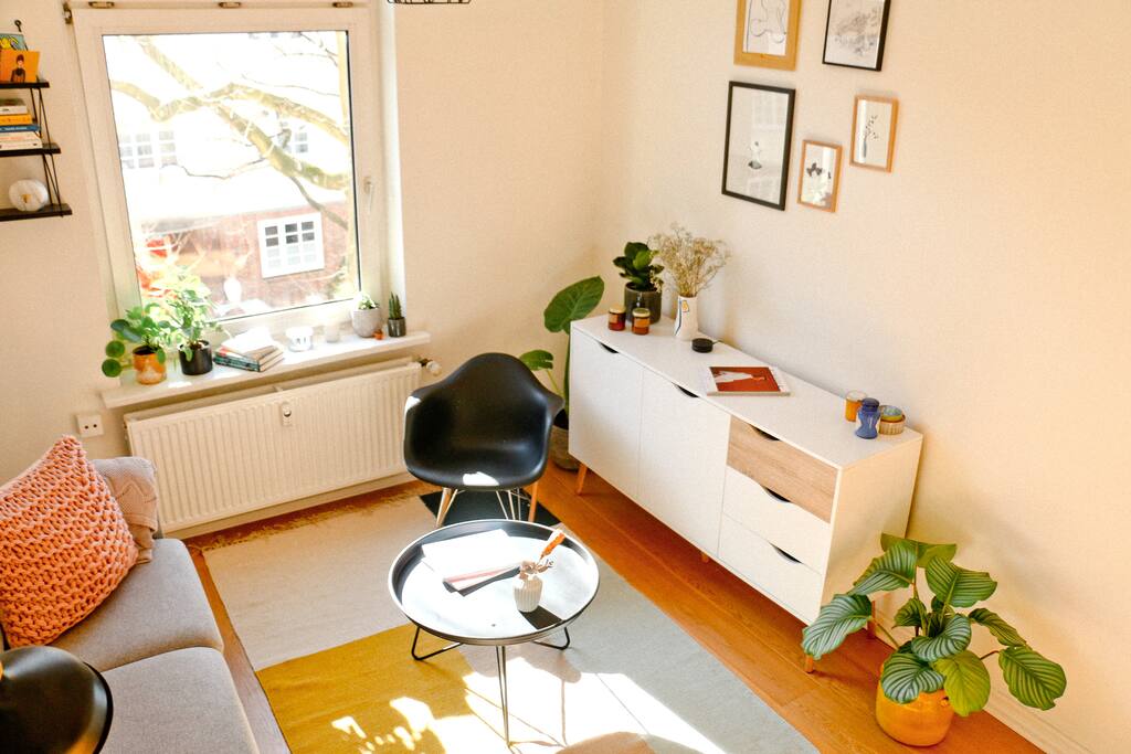 Der Wohnbereich mit Couch und Stuhl ist Herzstück der Wohnung.