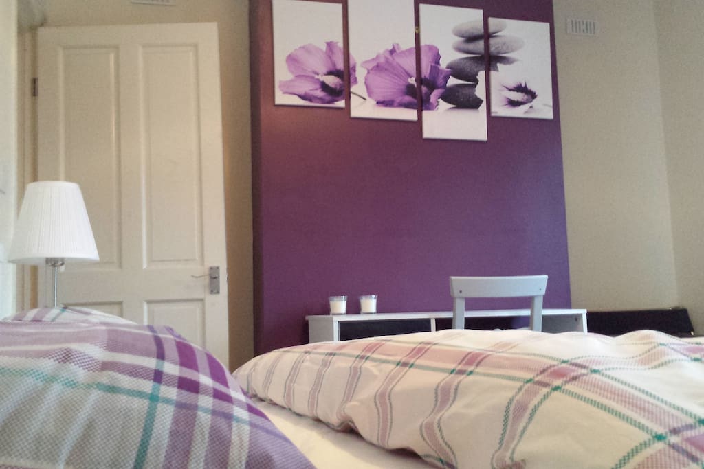 The spacious master bedroom, with storage, desk and armchair.