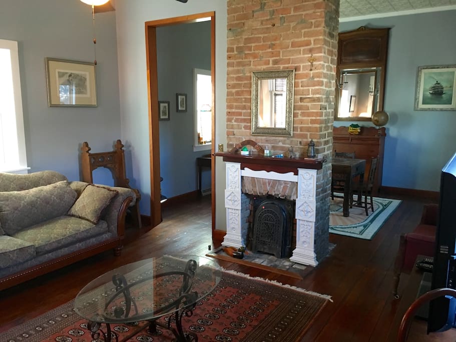 The exposed brick fireplace divides the living room and the dining room.