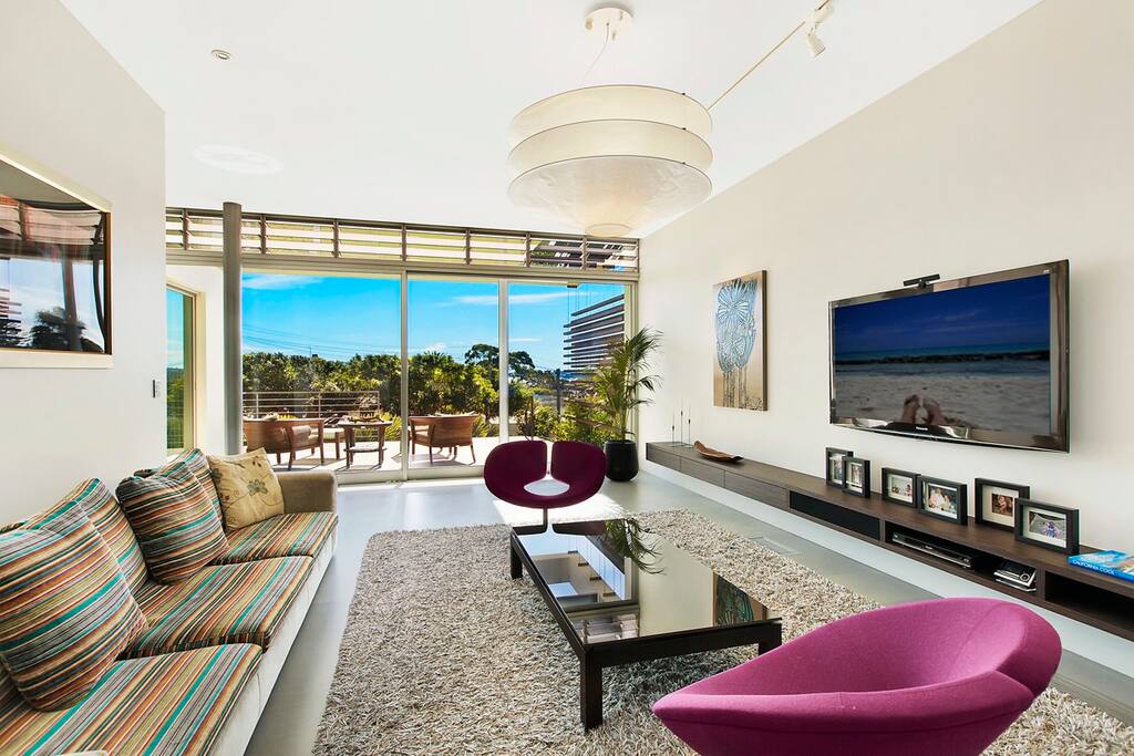 Family room with large screen TV and access to covered front terrace with peaceful views.