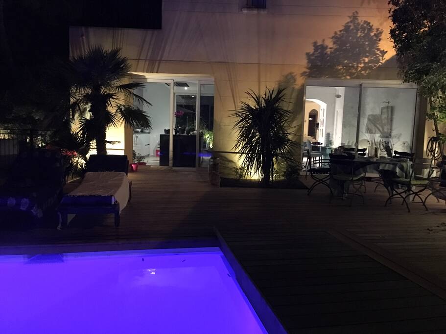 La terrasse côté piscine, avec table et chaises de jardin.