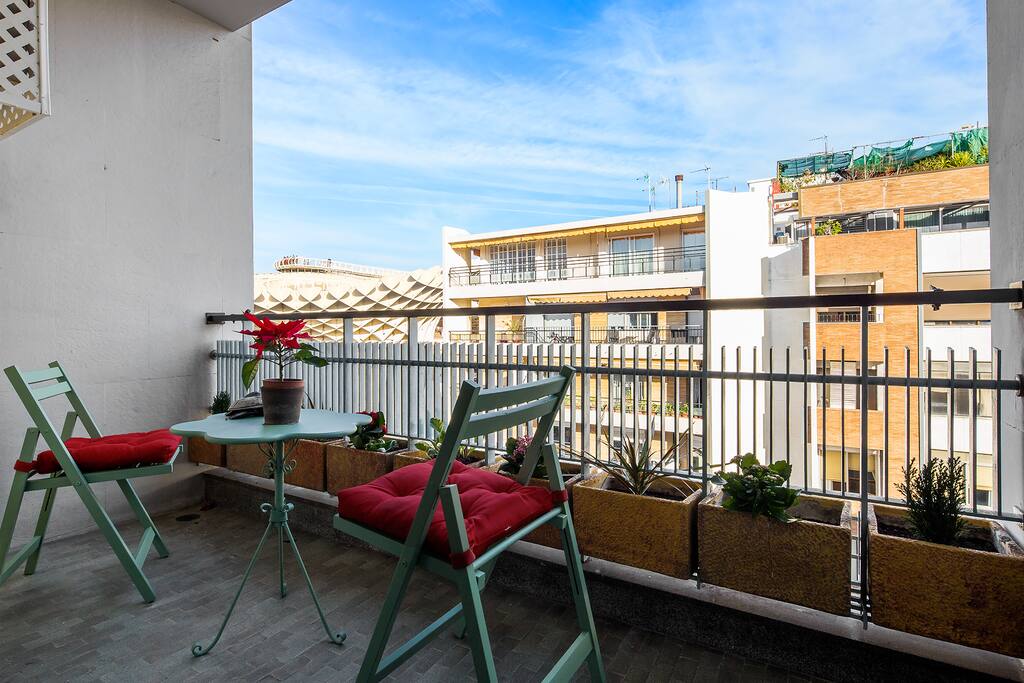 Balcony with a small table and chairs.