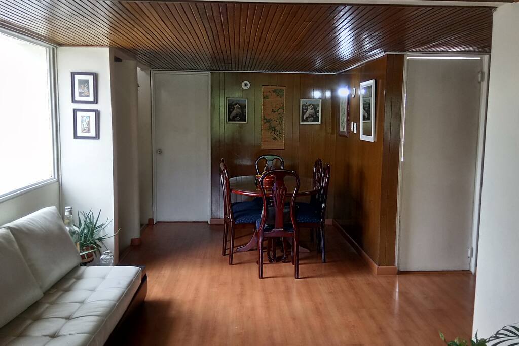 Comedor de seis puestos en madera, con sillas tapizadas, mesa con vidrio de protección, cuatro cuadros, dos de ellos oleos originales. una acuarela, uno en bordado. Un espejo
