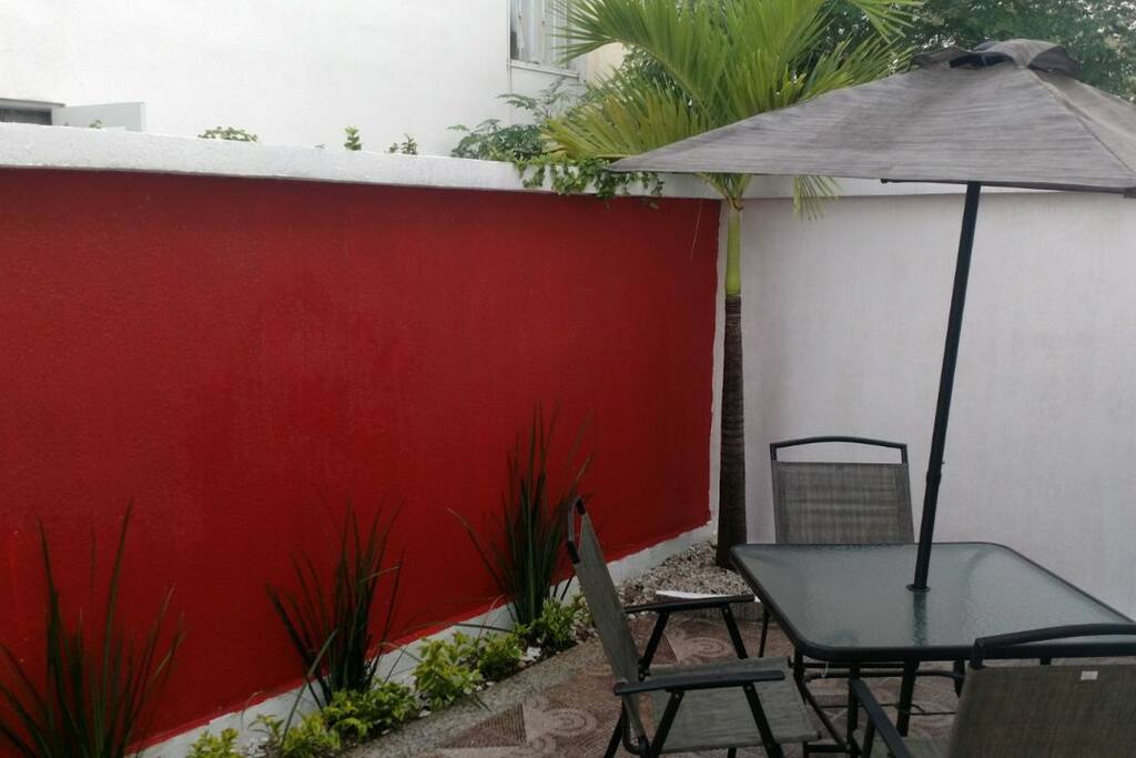 Patio trasero con juego de jardín como desayunador.