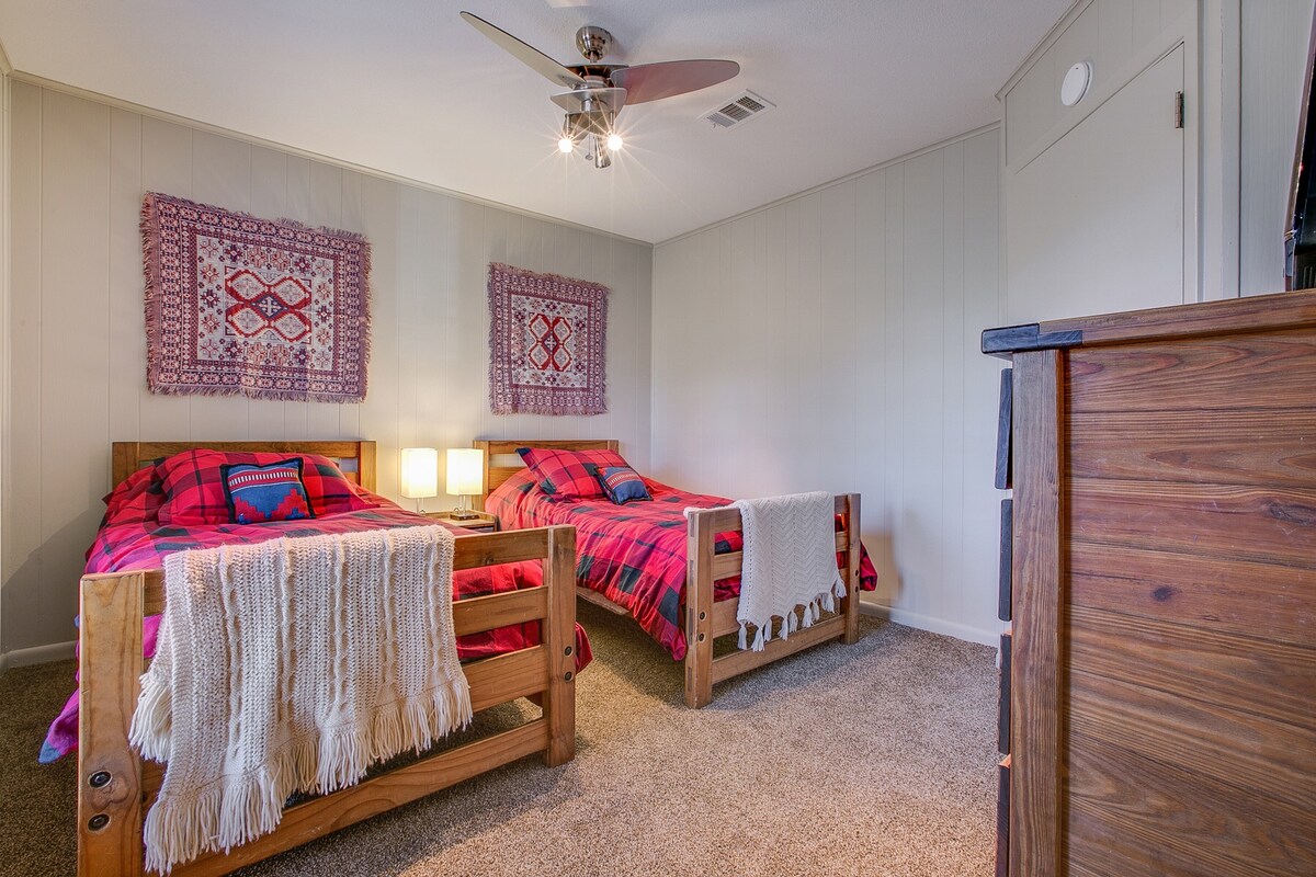 Dve samostatné postele s útulnými prikrývkami a nástennými vešiakmi.