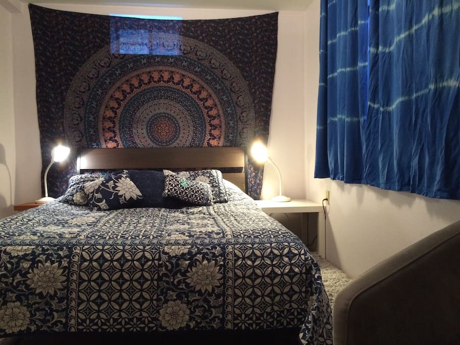 Bedroom at night. Comfortable bed and bedding, pleasant lighting, black out curtains for easy sleep.