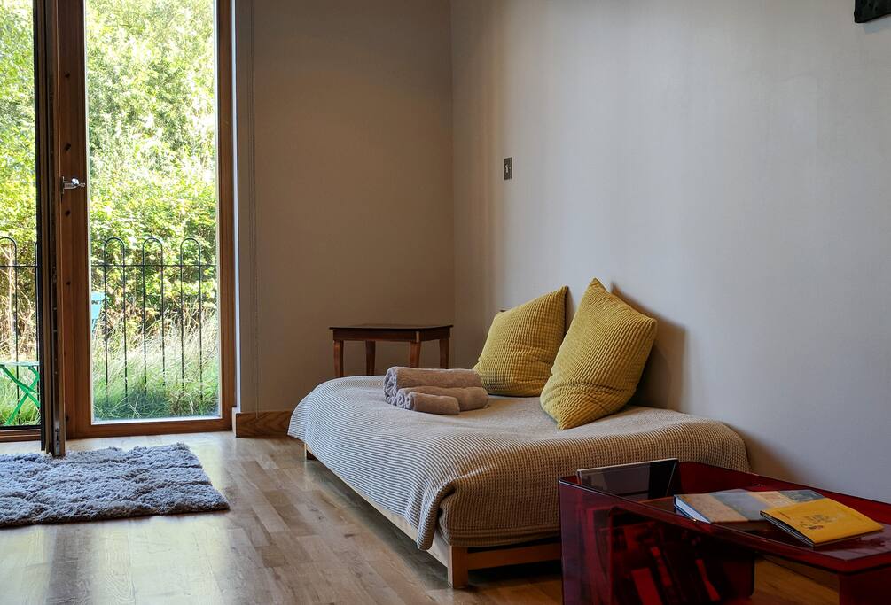 A single futon style sofa bed and wooden floor throughout