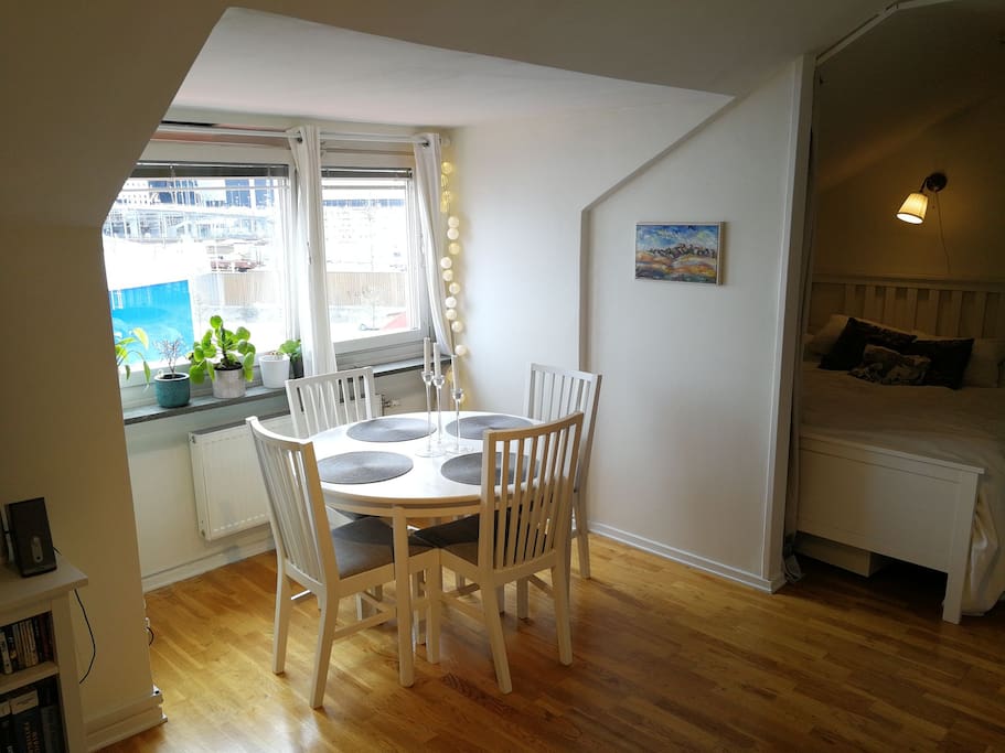 A dining table with space for 4 people stands next to the south-facing window in the living room.