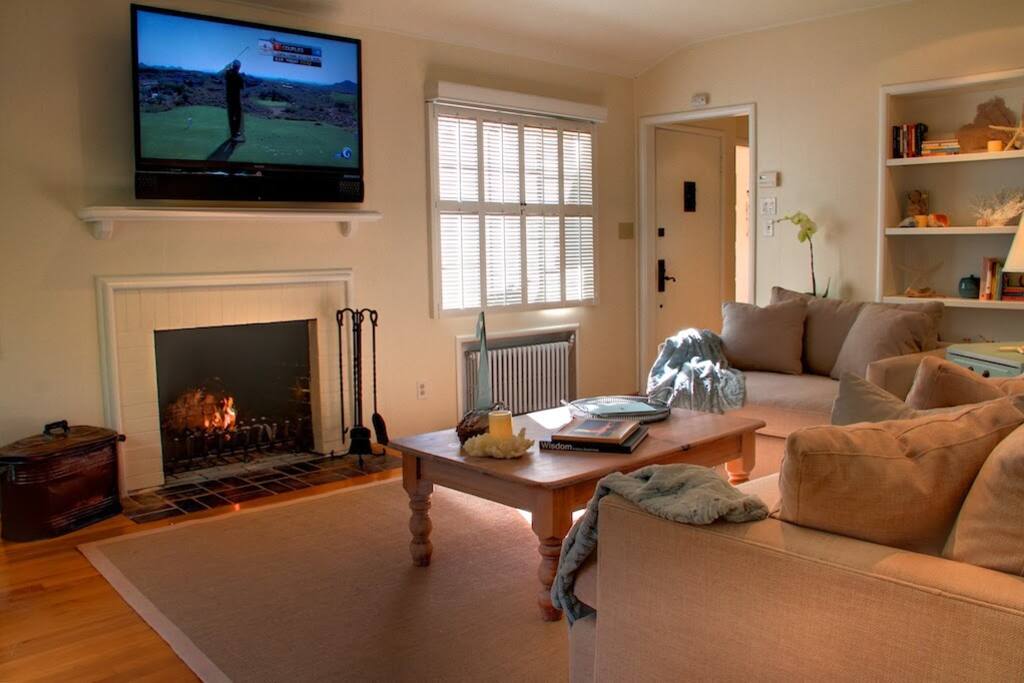 Living room has wood burning fireplace and flat screen HDTV.