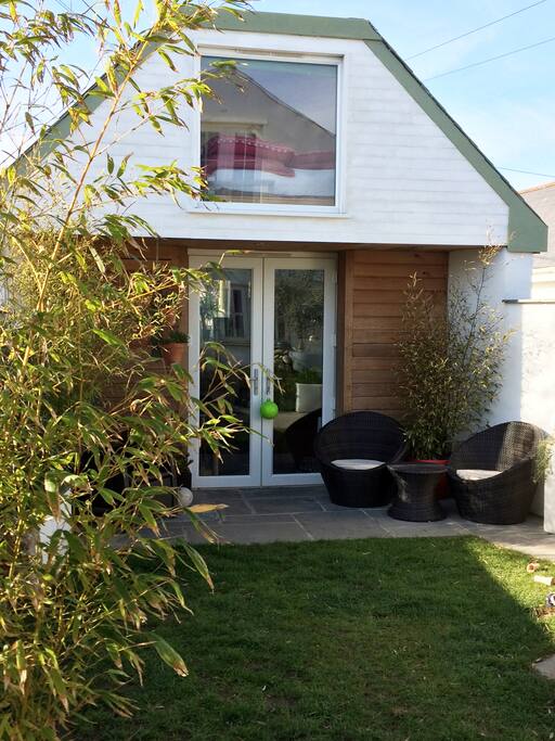 Outside, a small fully enclosed garden has been thoughtfully laid out with patio, seating for six, a water feature and palm trees.