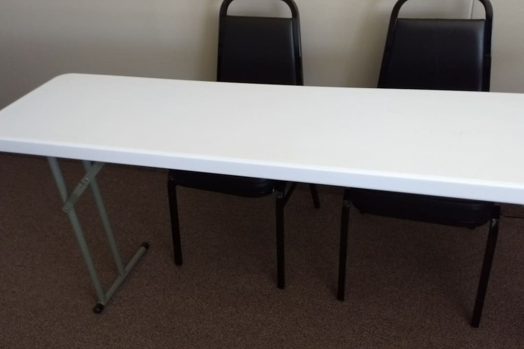 The room, a desk with chairs. There are two more desks and 6 more chairs, in case you might need.