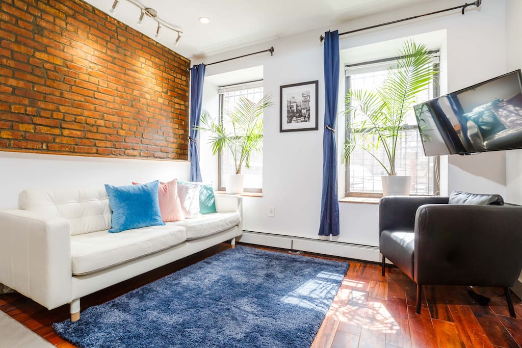 The living room features ample seating and wall-mounted flat screen TV with hundreds of entertainment options.