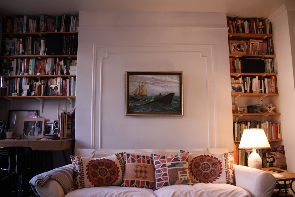 Living room: comfy couch, desk, and bookshelves