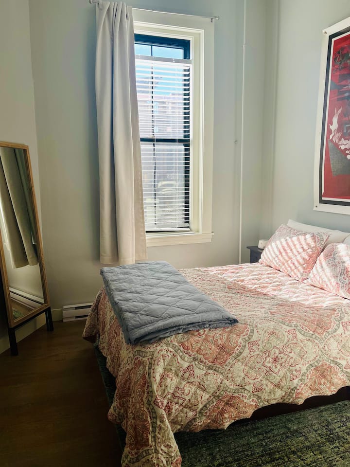 Chumba cha kulala kilicho na kitanda maradufu, mapazia ya kuongeza giza kwenye chumba, bandari ya chaja na mashine ya kupiga kelele nyeupe.