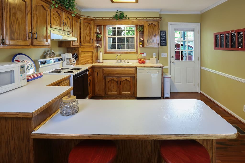 Fully furnished kitchen with oven, dishwasher, garbage disposal, and coffee pot.