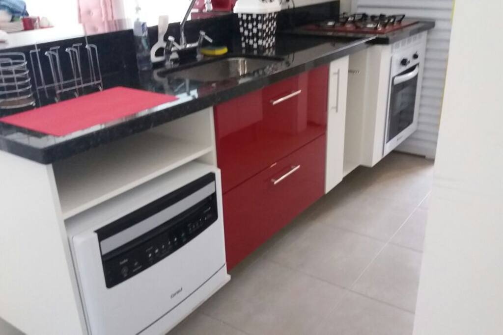 Cozinha com lava louças, forno, cooktop e coifa